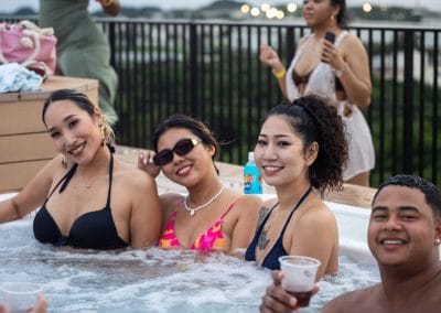 Three ladies and a man in a jacuzzi at an Okinawa pool party